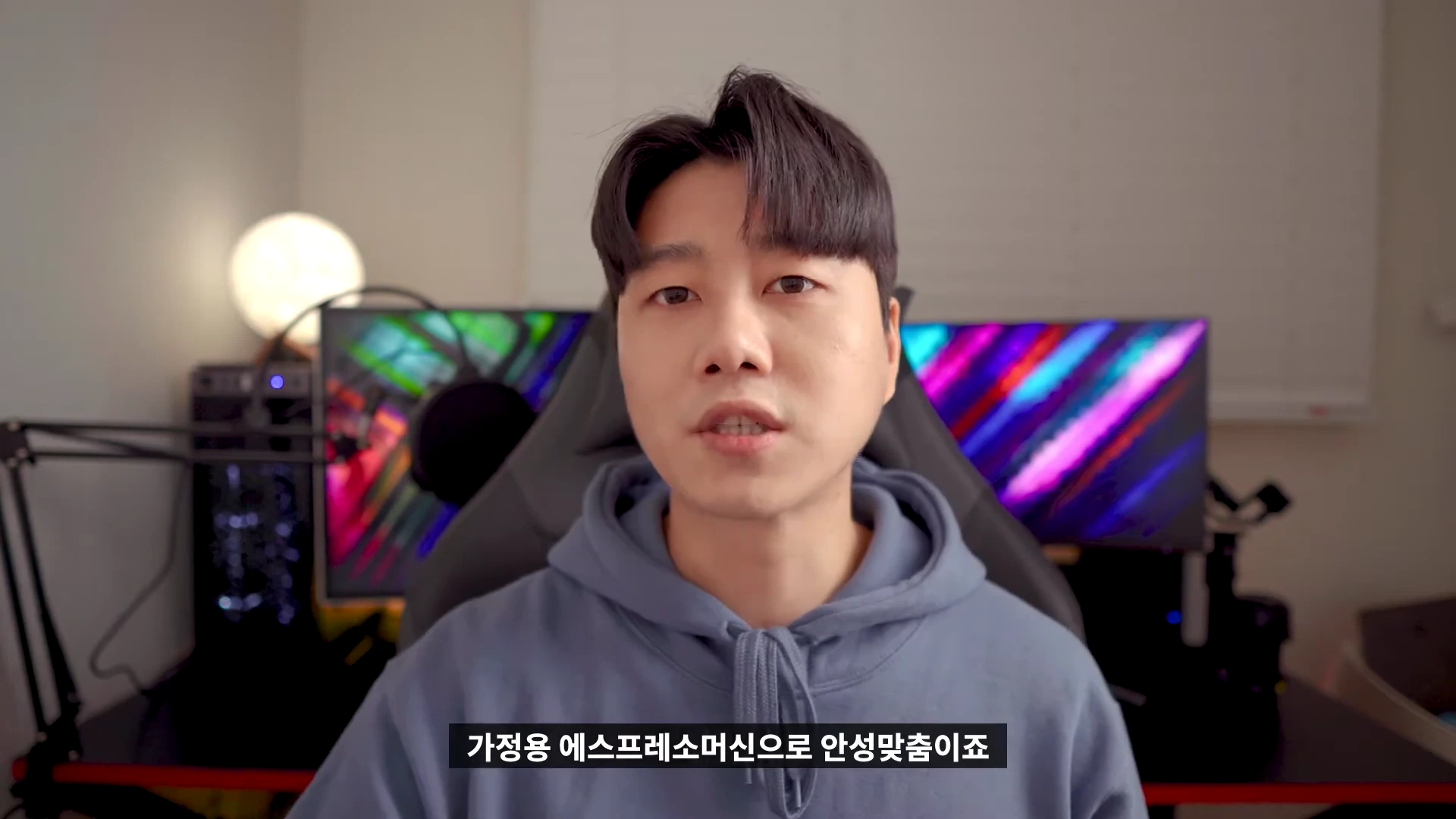 실내에서 후드티를 입은 남성이 정면을 바라보며 말하는 영상 화면입니다.