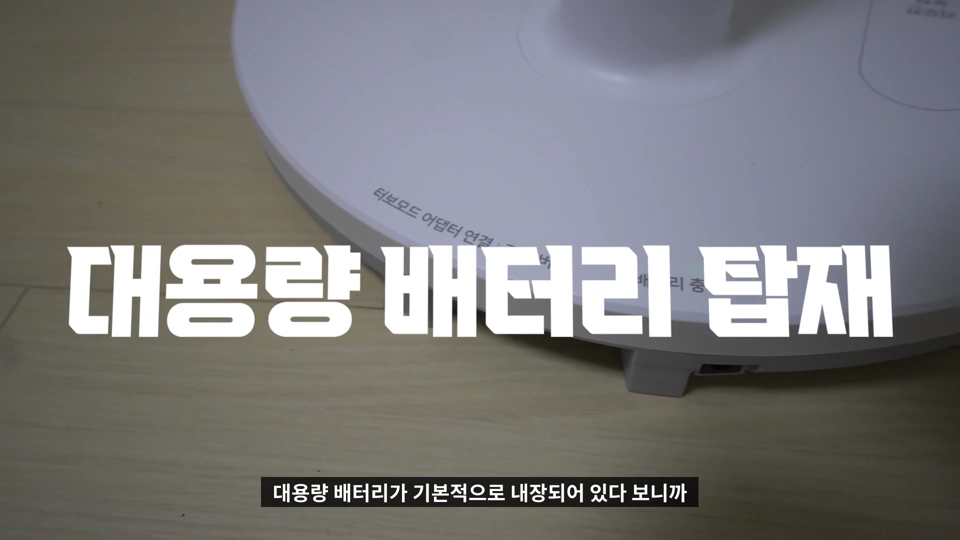 흰색 무선 선풍기의 바닥면이 클로즈업되어 있으며, 화면 중앙에는 '대용량 배터리 탑재'라는 큰 흰색 한글 자막이 강조되어 있습니다.