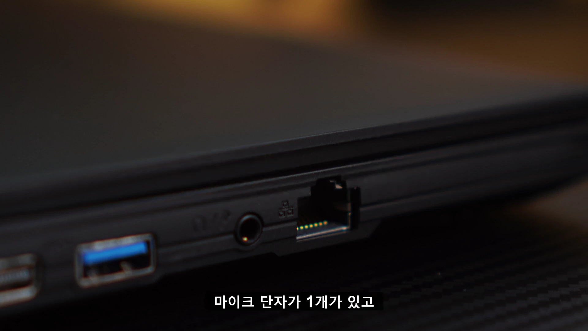 게이밍 노트북 측면에 배치된 USB 포트와 이어폰 단자, 유선 랜 포트가 보이는 클로즈업 사진