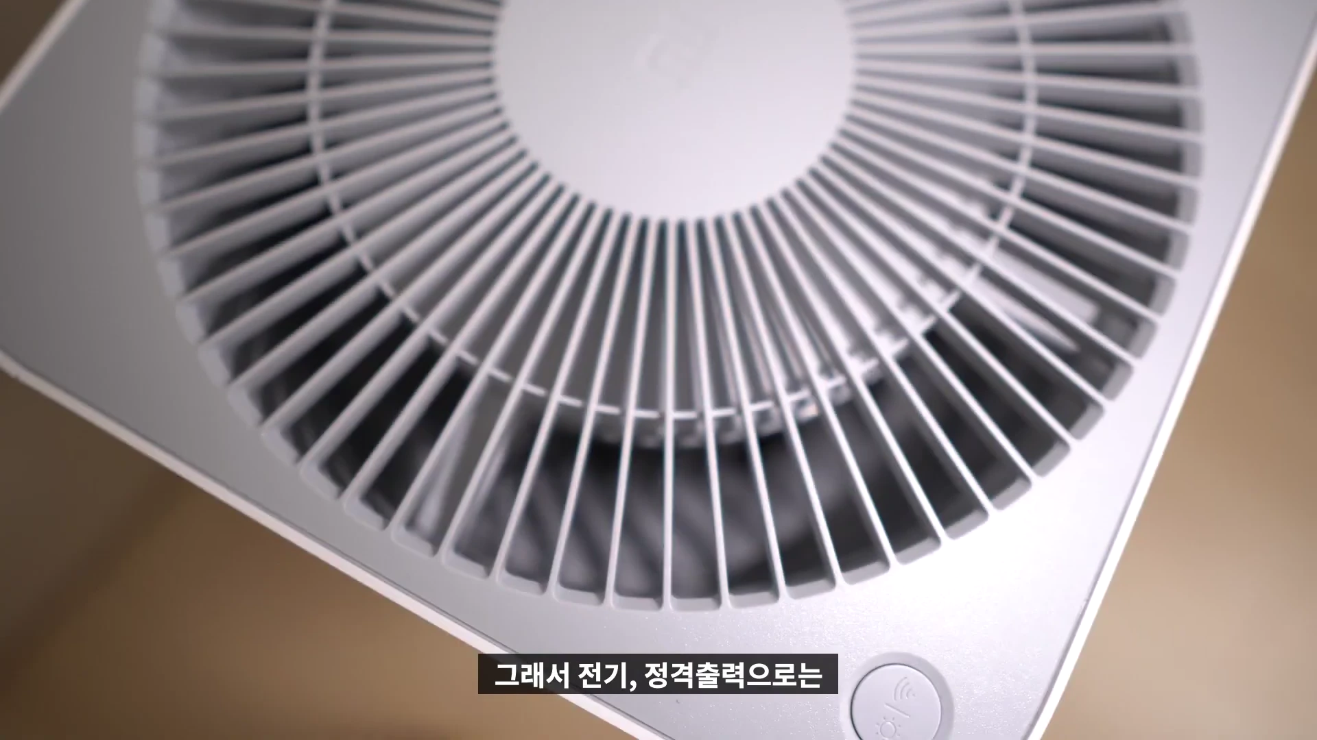 샤오미 공기청정기 상단의 원형 공기 배출구와 제어 버튼이 보이는 근접 샷