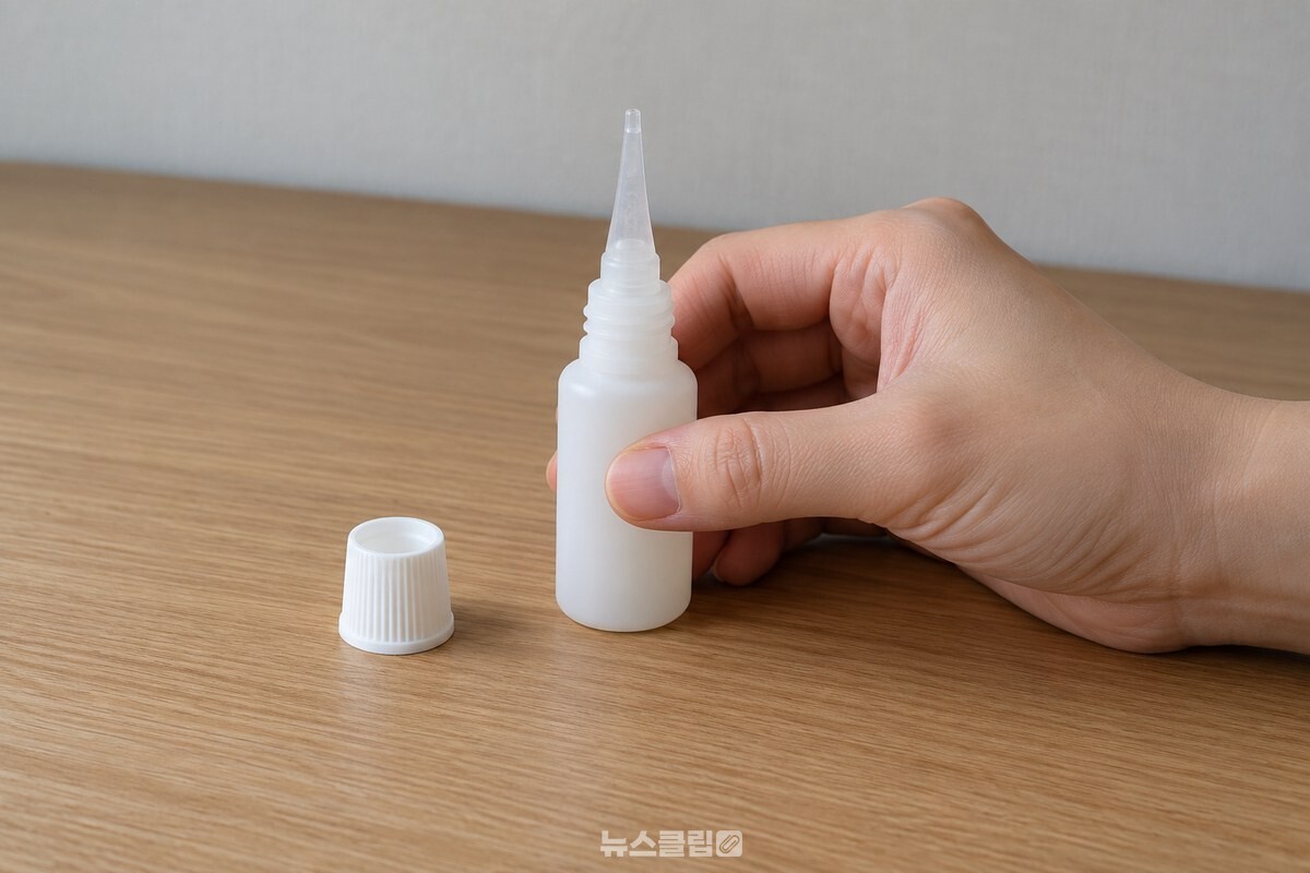 순간접착제의 입구를 위로 세우고 용기 바닥을 책상에 가볍게 톡톡 치는 모습. / 기사 이해를 돕기 위한 생성형 이미지
