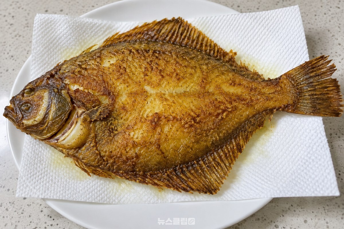 키친타월을 깐 접시에서 기름을 빼는 구운 가자미 / 기사 이해를 돕기 위한 생성형 이미지
