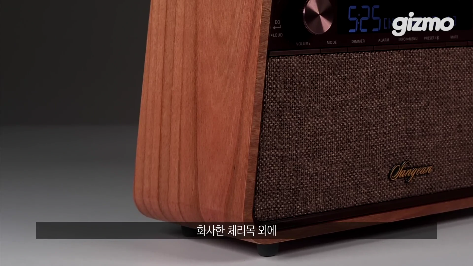 나무 소재의 외관과 패브릭 스피커 그릴이 적용된 산진 라디오의 측면 모습으로, 상단에는 디지털 디스플레이와 조절 다이얼이 배치되어 있습니다.