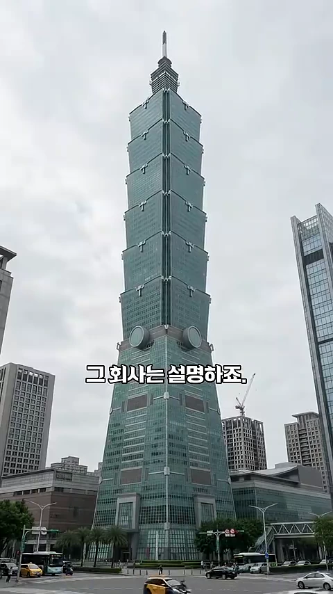 타이베이 101 빌딩의 전체 외관이 담긴 로우앵글 사진. 화면 중앙에 '그 회사는 설명하죠.'라는 자막이 배치되어 있다.