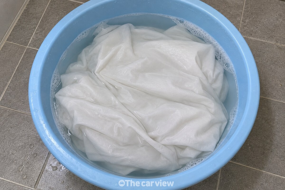 거품이 옅게 남은 물에 흰 베갯잇이 고르게 잠겨 있는 모습 / 기사 이해를 돕기 위한 생성형 이미지