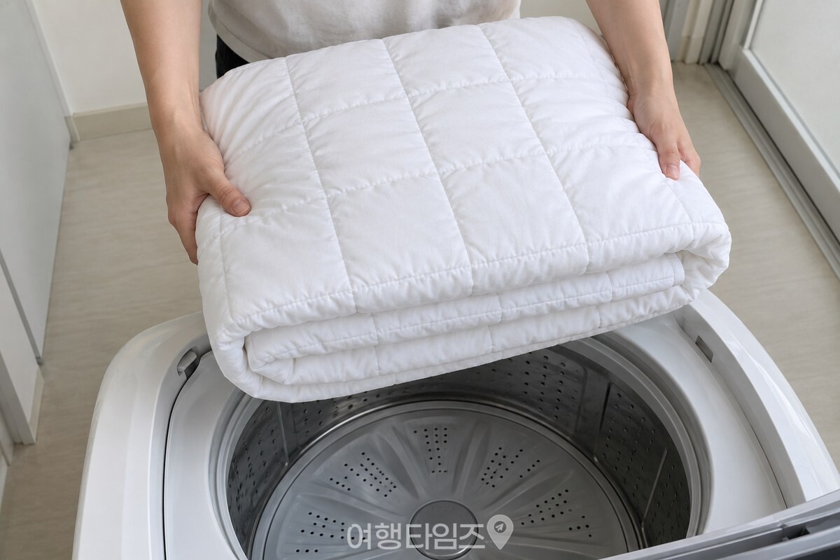 가로 방향까지 번갈아 접어 네모난 층이 보이게 만든 이불을 두 손으로 받친 모습. / 기사 이해를 돕기 위한 생성형 이미지