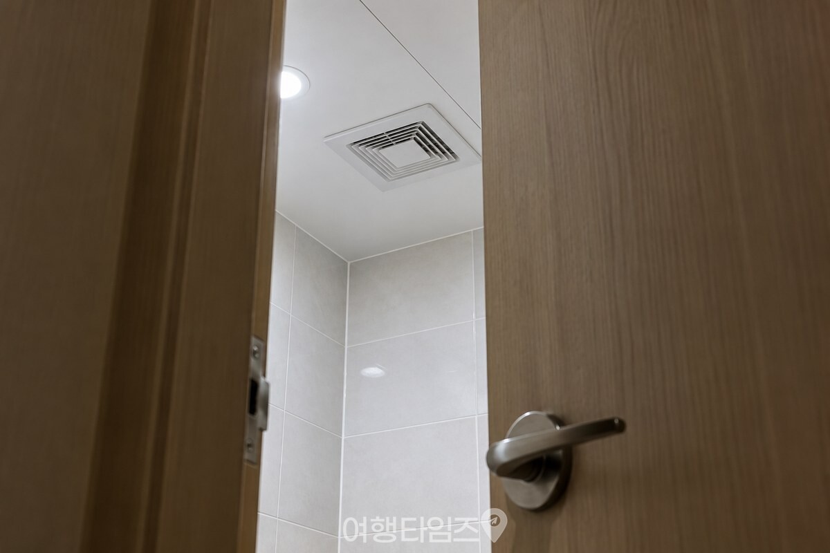 욕실 문을 조금 열어 둔 채 천장 환풍기를 켠 깨끗한 욕실 모습. / 기사 이해를 돕기 위한 생성형 이미지