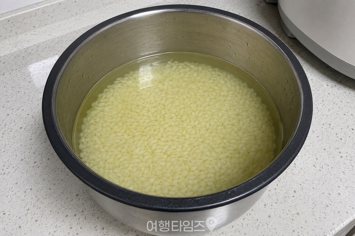 연한 녹찻물에 불어 하얗게 변한 쌀알이 담긴 밥솥 내솥 / 기사 이해를 돕기 위한 생성형 이미지