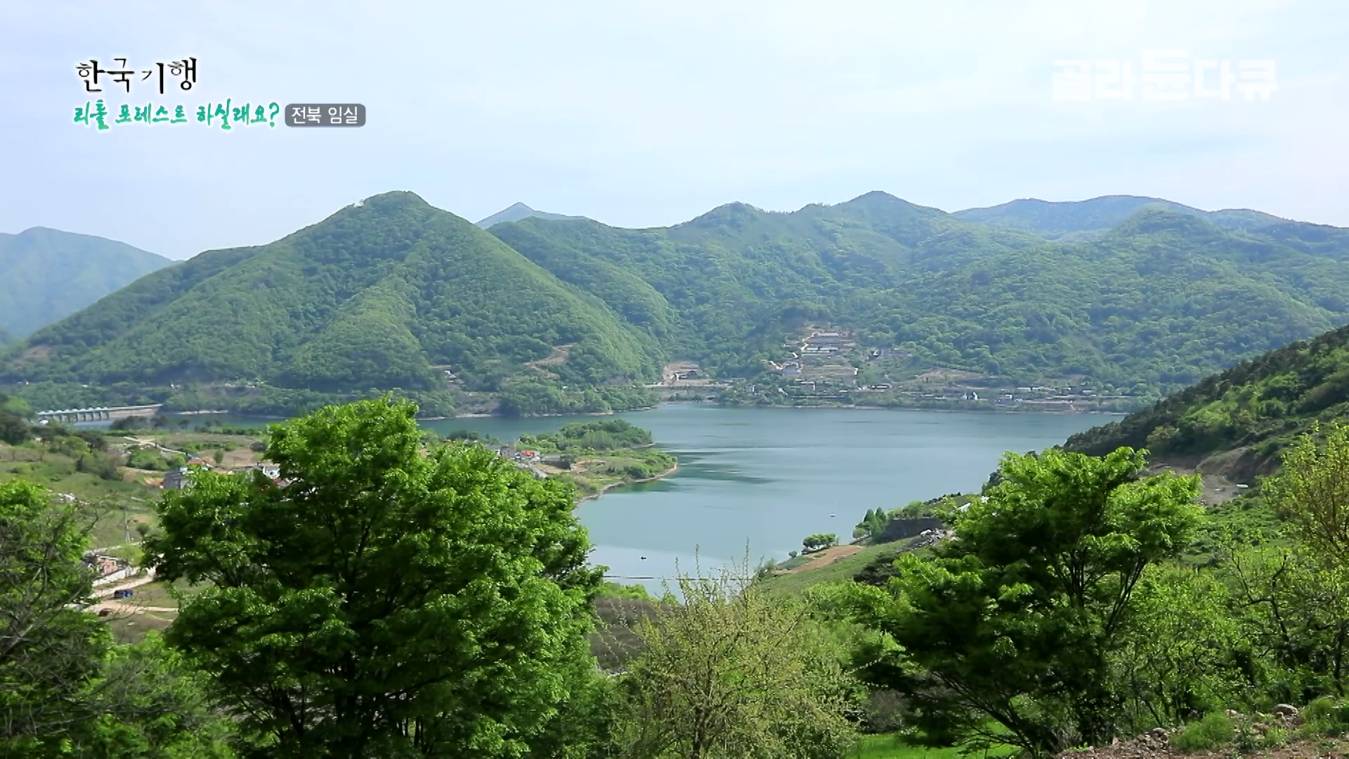 전북 임실의 산으로 둘러싸인 옥정호의 푸른 호수와 그 주변의 녹음이 짙은 자연 풍경을 담은 풍경 영상 화면