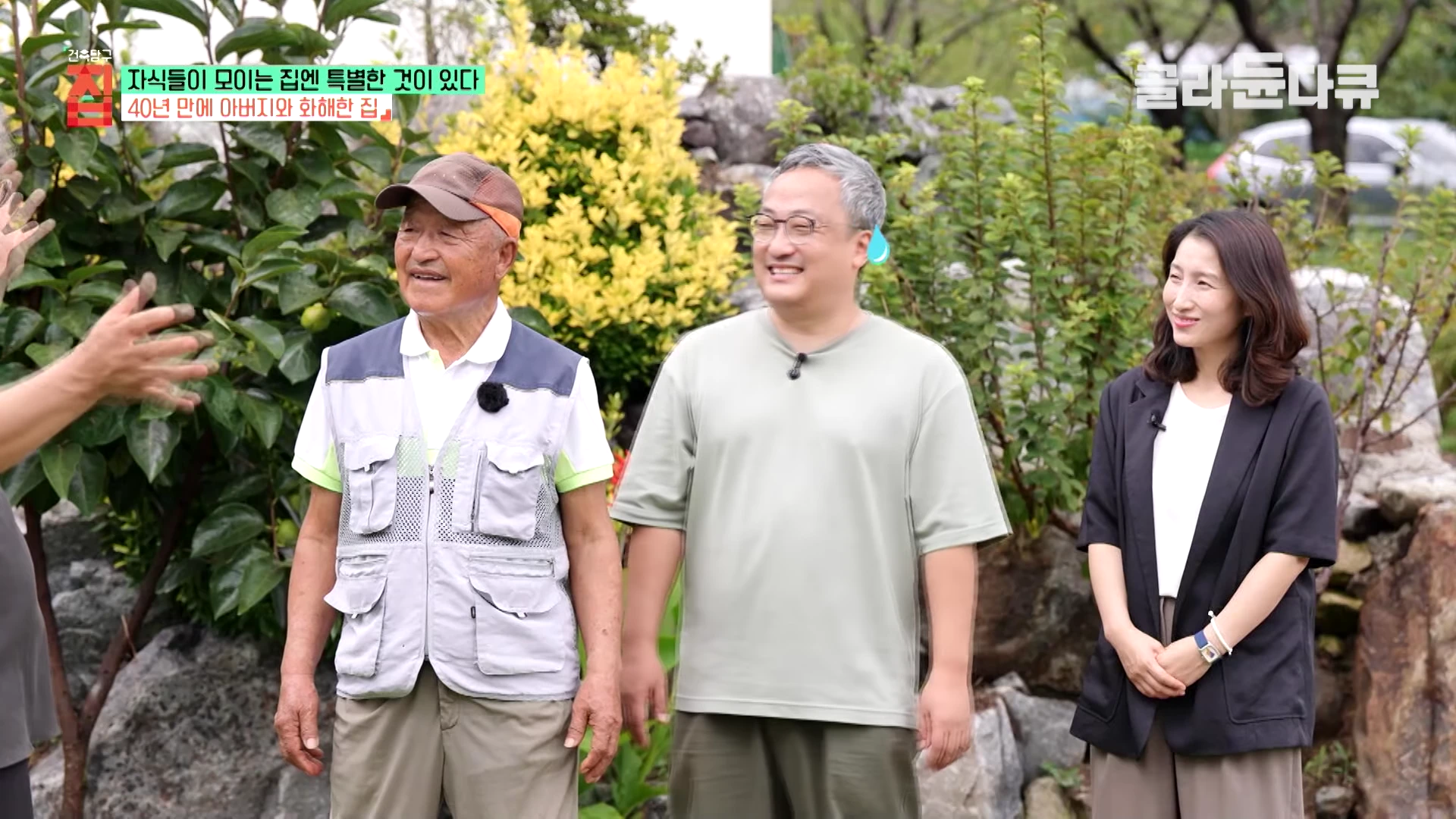 실외 정원에서 나란히 서서 이야기를 나누고 있는 세 사람의 모습. 왼쪽에는 모자를 쓴 연로한 남성이 있고, 가운데와 오른쪽에는 중년 남성과 여성이 서 있다.