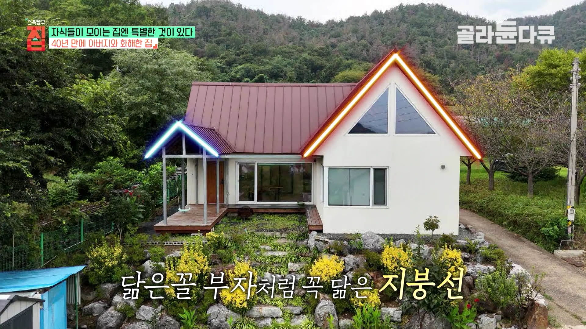 정원과 암석이 어우러진 앞마당 너머로, 박공지붕이 돋보이는 흰색 외벽의 단독 주택이 서 있고 왼쪽 포치에는 그네가 설치되어 있다.