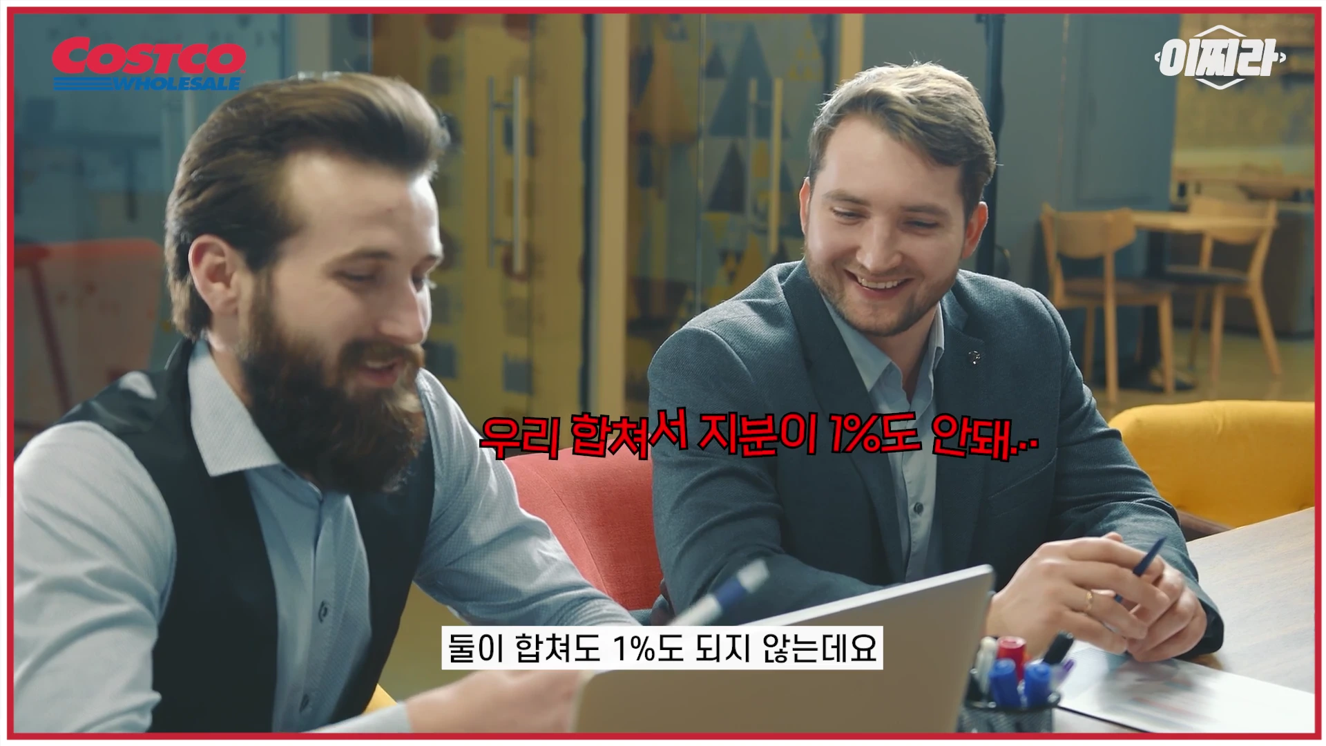 정장을 입은 두 남성이 사무실 책상에 앉아 웃으며 대화를 나누고 있는 모습이 담긴 영상 캡처 화면이며, 화면 중앙에 '우리 합쳐서 지분이 1%도 안돼'라는 자막이 표시되어 있습니다.