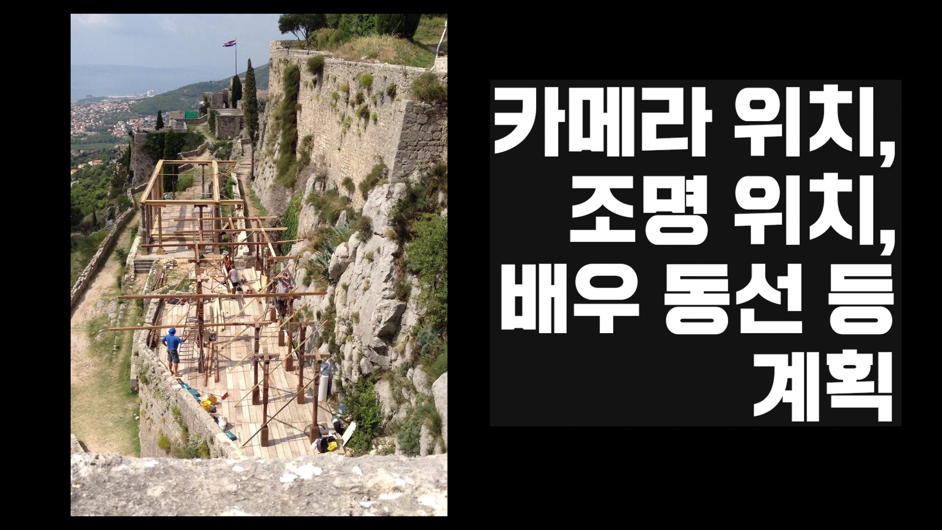 고대 성벽 유적지 옆에 나무 데크와 구조물이 설치된 야외 로케이션 현장과 그 옆에 흰색 글씨로 촬영 계획 요소들이 적힌 검은색 박스가 놓인 화면