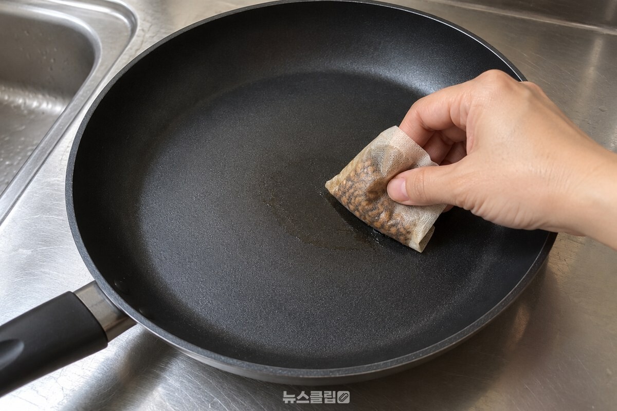 식힌 프라이팬을 보리차 티백으로 닦는 손 / 기사 이해를 돕기 위한 생성형 이미지