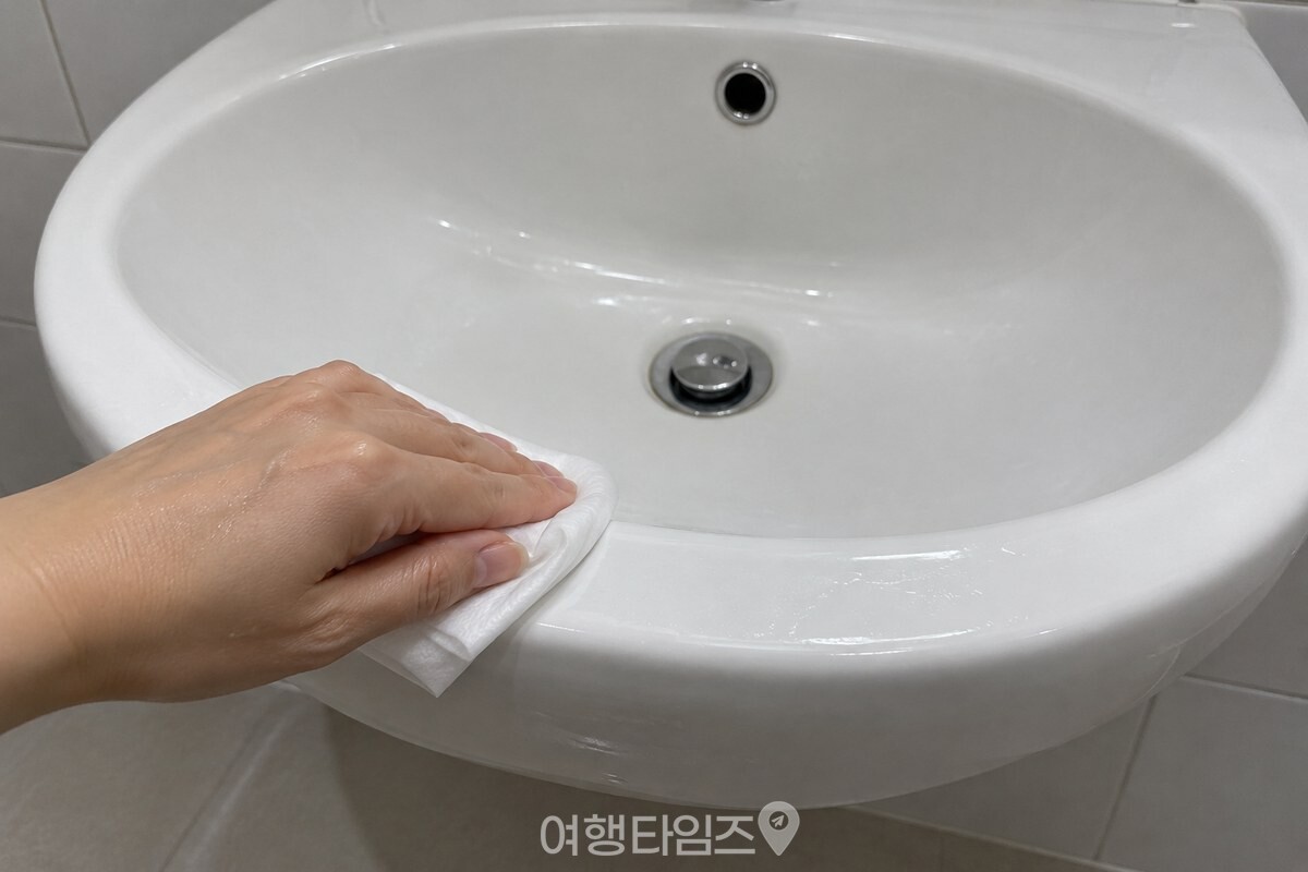 접은 클렌징티슈로 세면대 가장자리를 닦는 모습 / 기사 이해를 돕기 위한 생성형 이미지