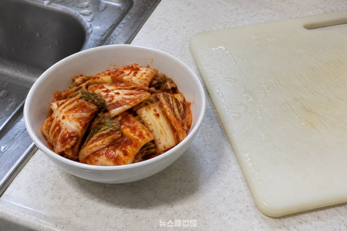 물기 남은 도마 옆 그릇에 담은 썬 김치 / 기사 이해를 돕기 위한 생성형 이미지
