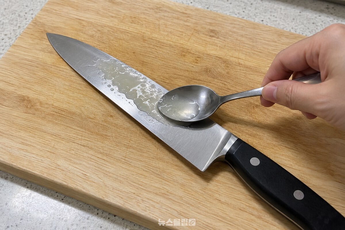 도마 위에 놓인 칼날 한쪽에 숟가락으로 양파즙을 바르는 모습 / 기사 이해를 돕기 위한 생성형 이미지