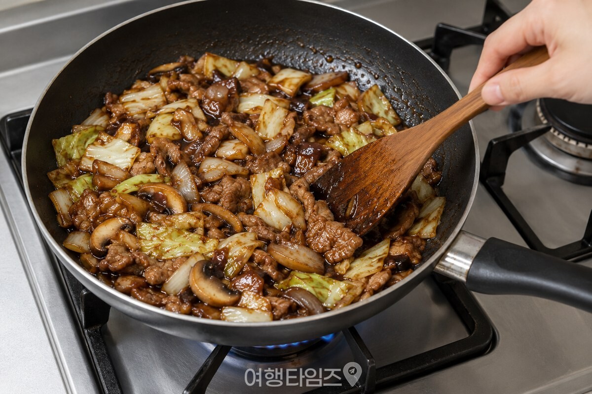 주걱으로 춘장 양념 제육볶음을 섞는 모습 / 기사 이해를 돕기 위한 생성형 이미지
