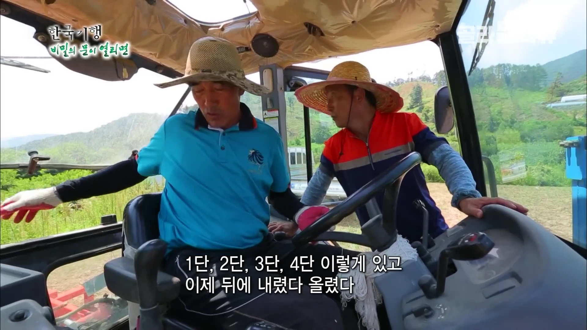 트랙터 운전석에 앉은 선배 농부와 옆에서 조작법을 가르쳐 주는 초보 농부의 모습