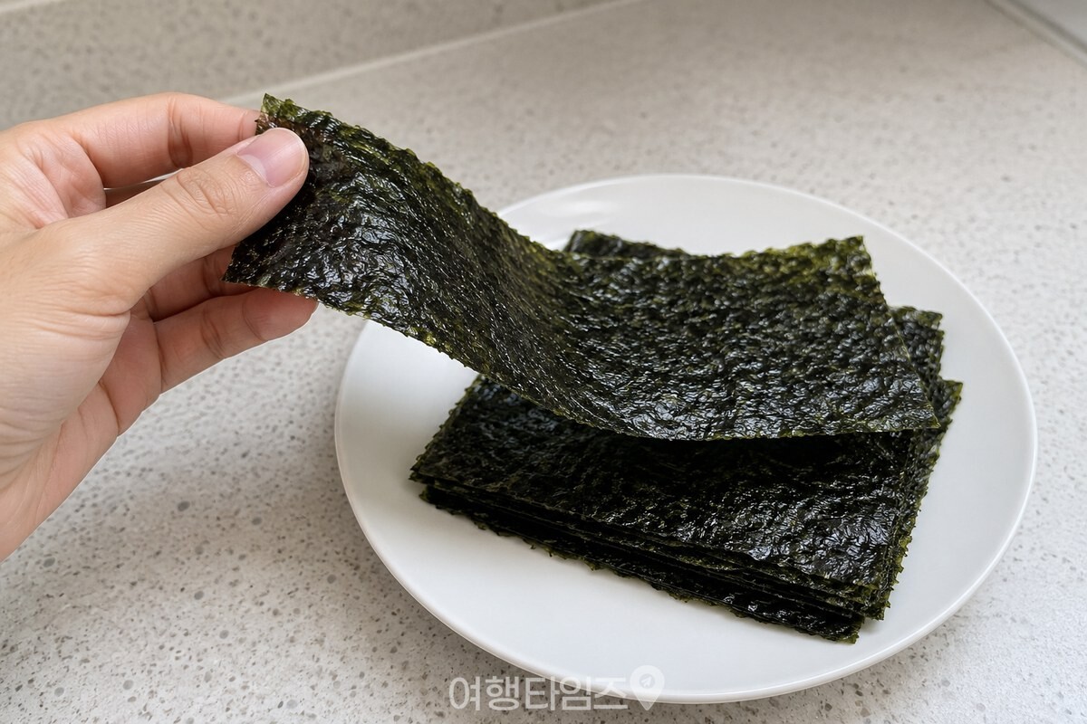 손끝에서 부드럽게 휘는 마른 김 한 장 / 기사 이해를 돕기 위한 생성형 이미지