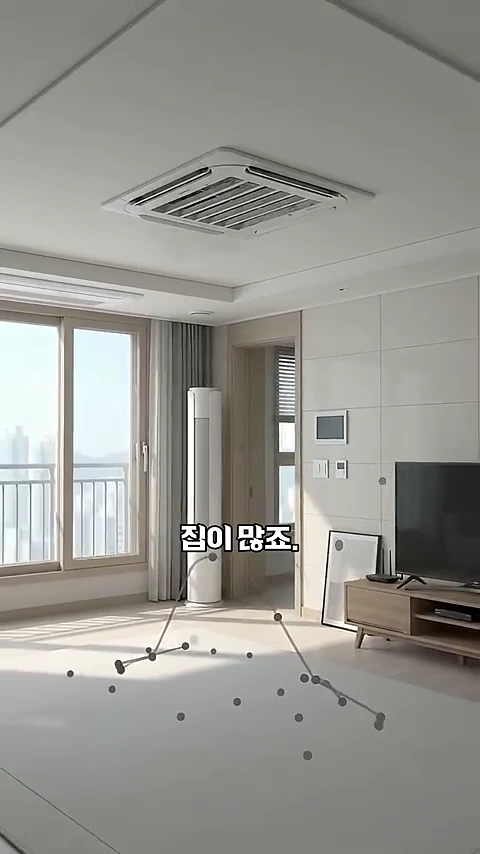 깔끔하게 정돈된 거실 천장에 시스템 에어컨과 환기 장치 흡입구가 설치되어 있고, 화면 중앙에 '짐이 많죠.'라는 자막이 표시된 영상 캡처 화면입니다.