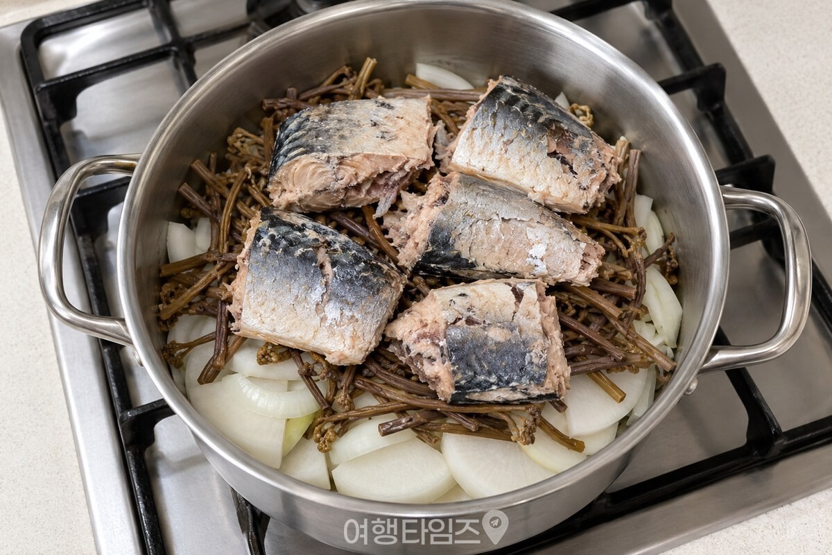 무와 양파, 고사리 위에 고등어를 차례로 올린 냄비 / 기사 이해를 돕기 위한 생성형 이미지