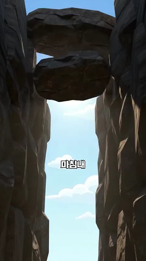 양쪽으로 높고 거대한 암벽이 솟아 있고, 그 사이의 좁고 깊은 골짜기 위로 맑은 하늘과 구름이 보이는 수직으로 절개된 통로의 모습이며, 화면 중앙에 '마침내'라는 자막이 적혀 있다.