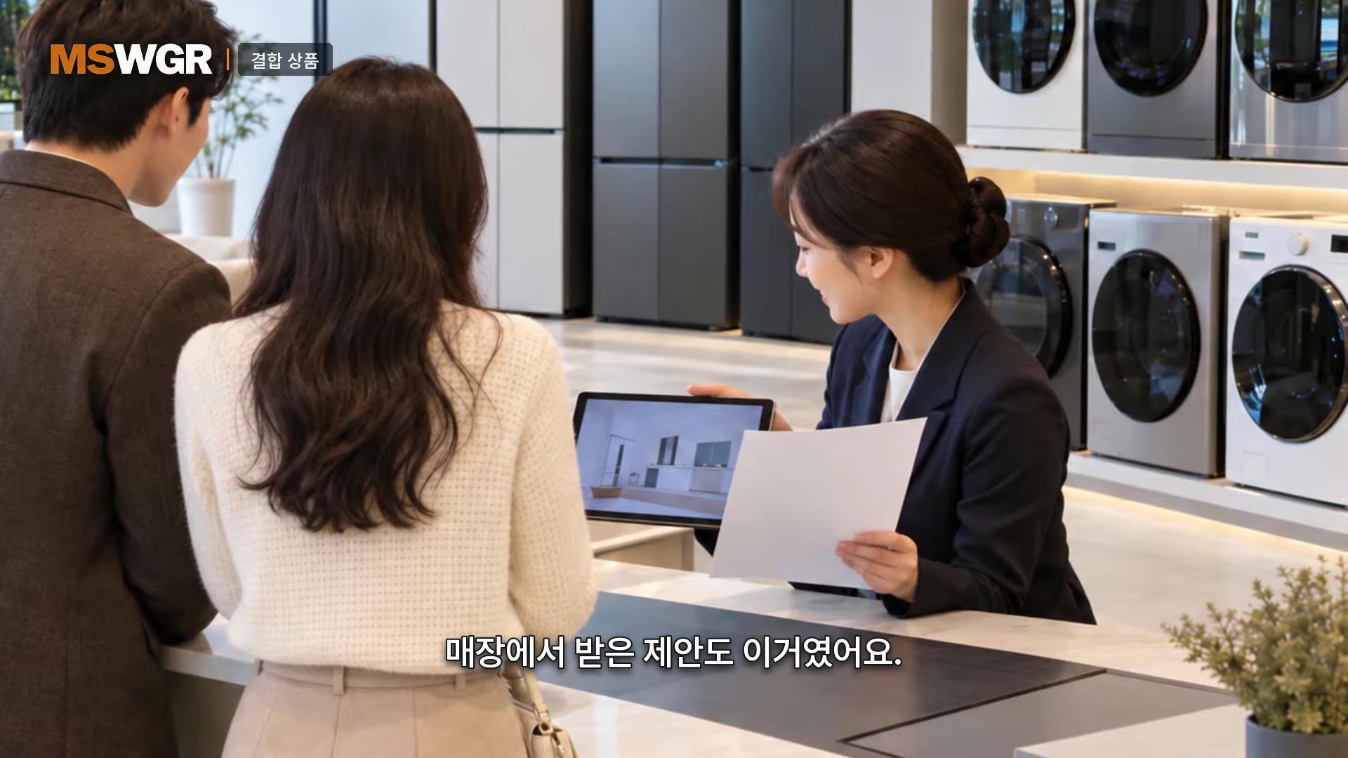 가전제품 매장에서 판매원이 태블릿과 서류를 들고 젊은 남녀 커플에게 상품을 설명하고 있는 모습