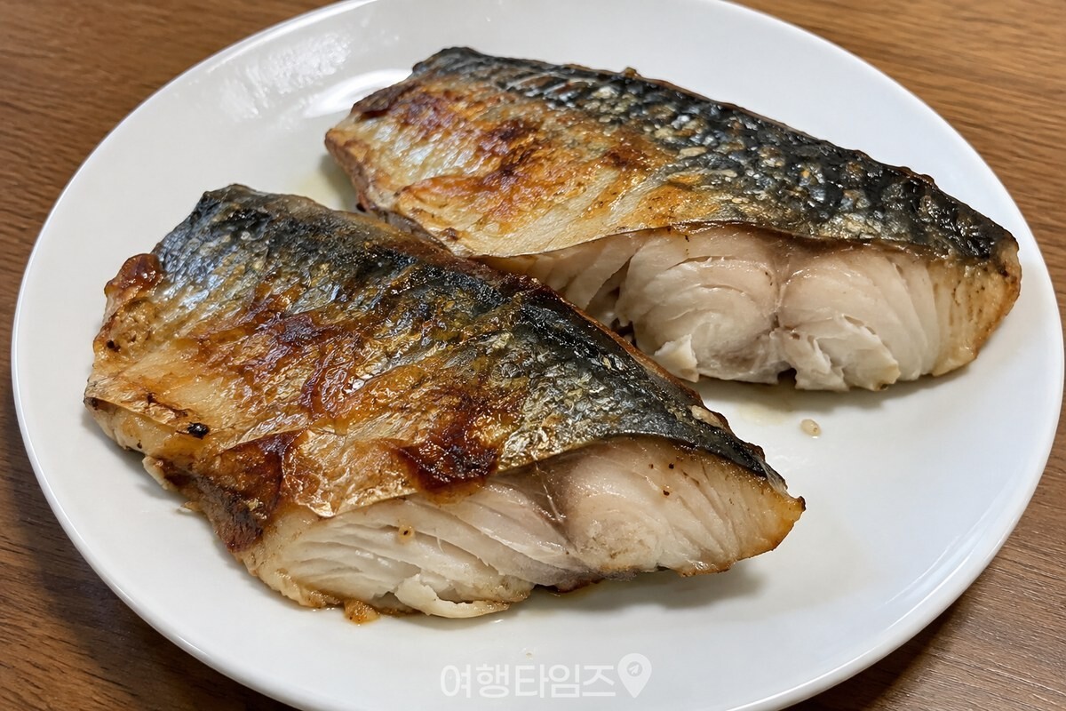 노릇하게 구운 고등어 토막이 담긴 흰 접시 / 기사 이해를 돕기 위한 생성형 이미지