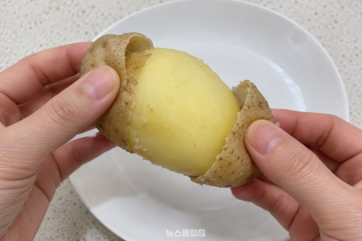 가운데 칼집을 따라 껍질이 두 쪽으로 벗겨진 삶은 감자 / 기사 이해를 돕기 위한 생성형 이미지