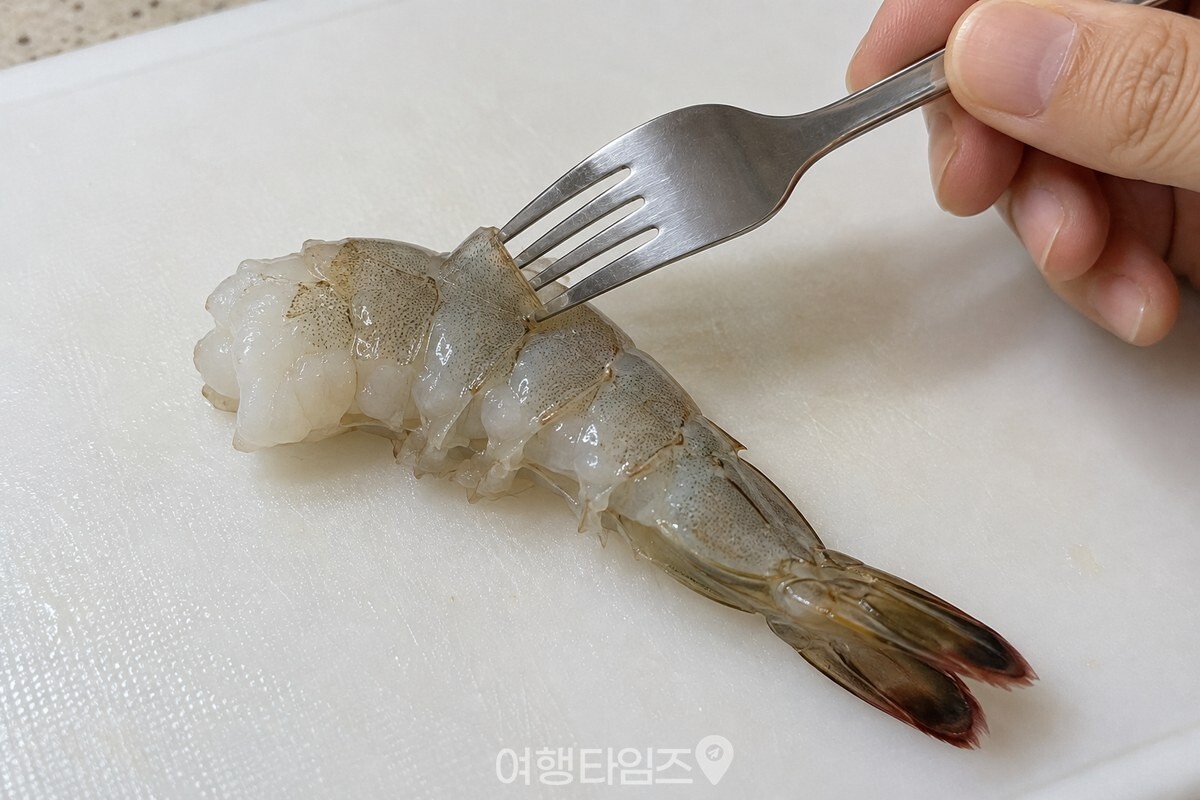 등껍질 아래로 포크 날 하나를 넣은 새우 / 기사 이해를 돕기 위한 생성형 이미지