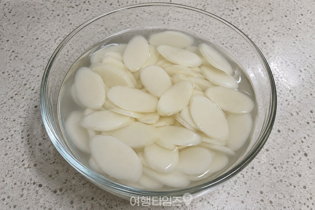 미지근한 물에 불린 떡국떡이 담긴 유리 그릇 / 기사 이해를 돕기 위한 생성형 이미지