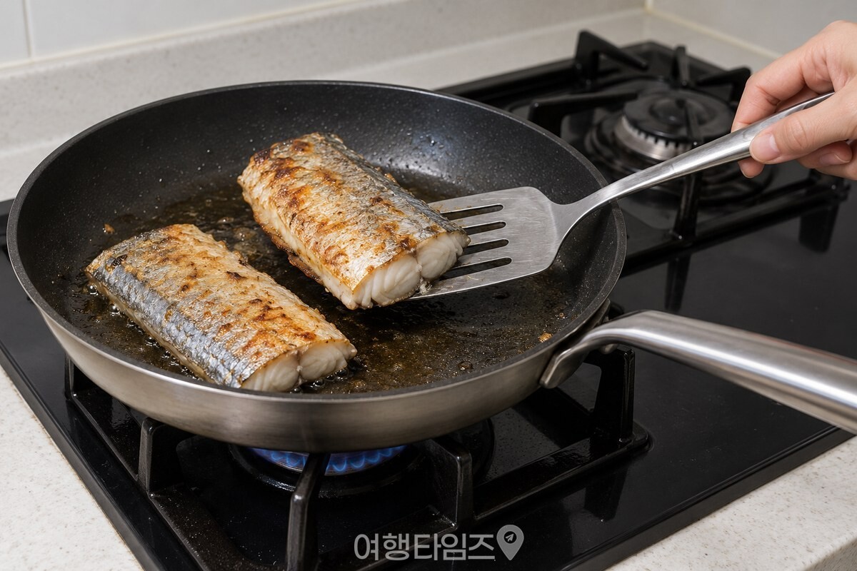 긴 뒤집개로 갈치 토막을 조심스럽게 뒤집는 모습 / 기사 이해를 돕기 위한 생성형 이미지