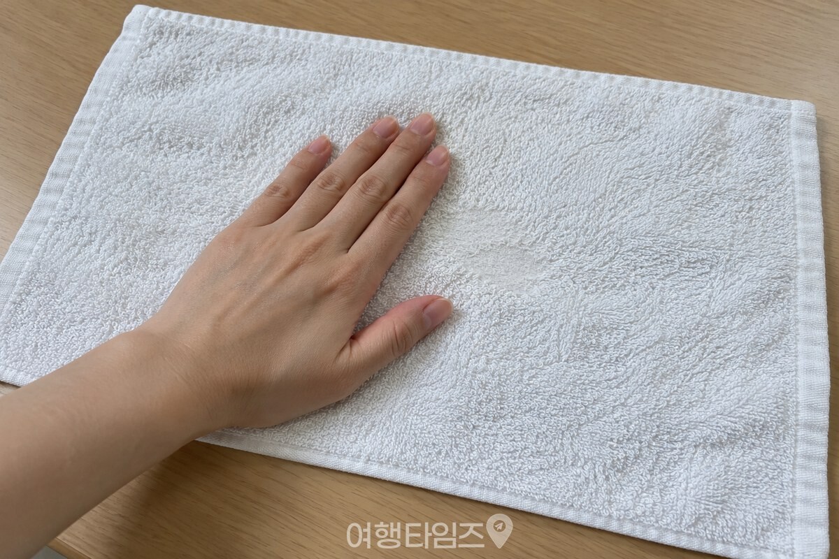 펼친 수건 표면을 손바닥으로 쓸어 보는 모습 / 기사 이해를 돕기 위한 생성형 이미지
