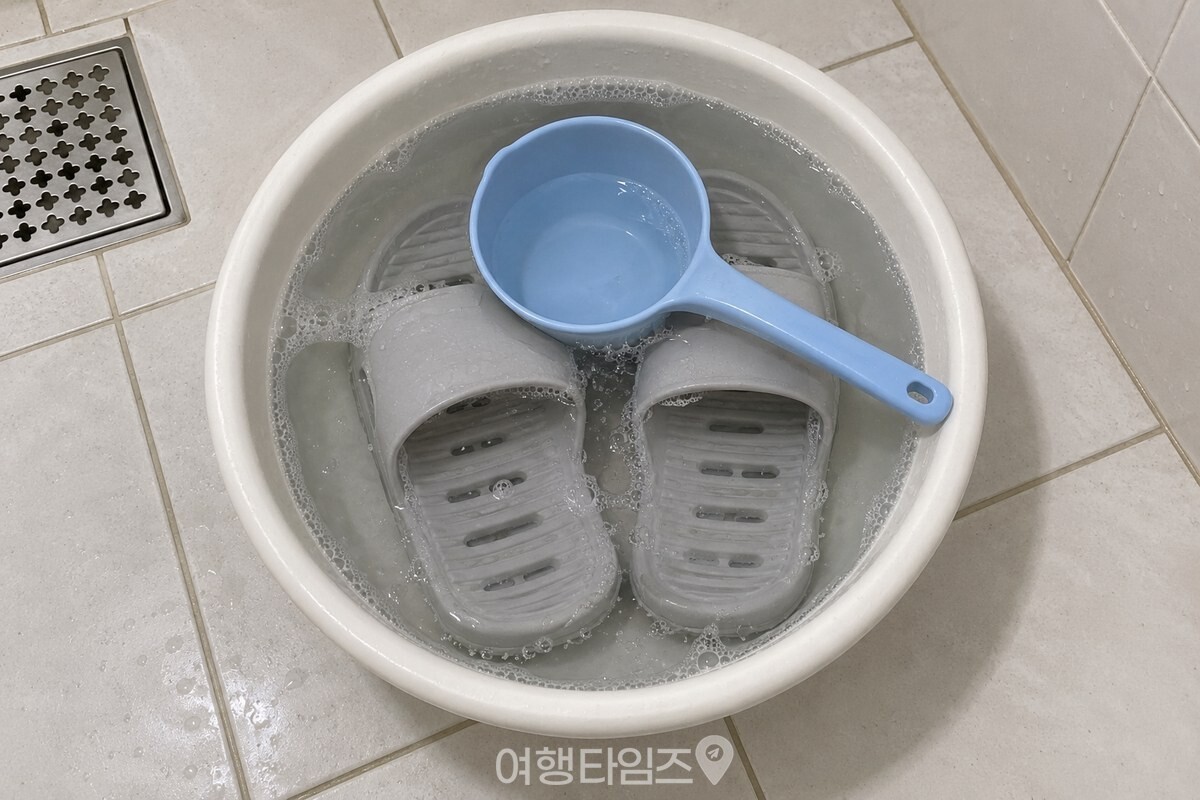 찬물과 옅은 세제 거품을 담은 대야에 욕실화를 완전히 담가 둔 모습 / 기사 이해를 돕기 위한 생성형 이미지