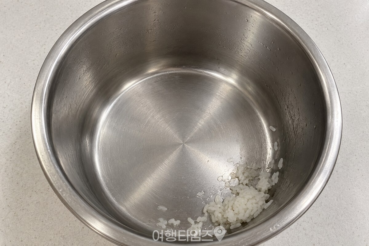 바닥 가장자리에 소량의 밥알이 붙은 스테인리스 내솥 / 기사 이해를 돕기 위한 생성형 이미지