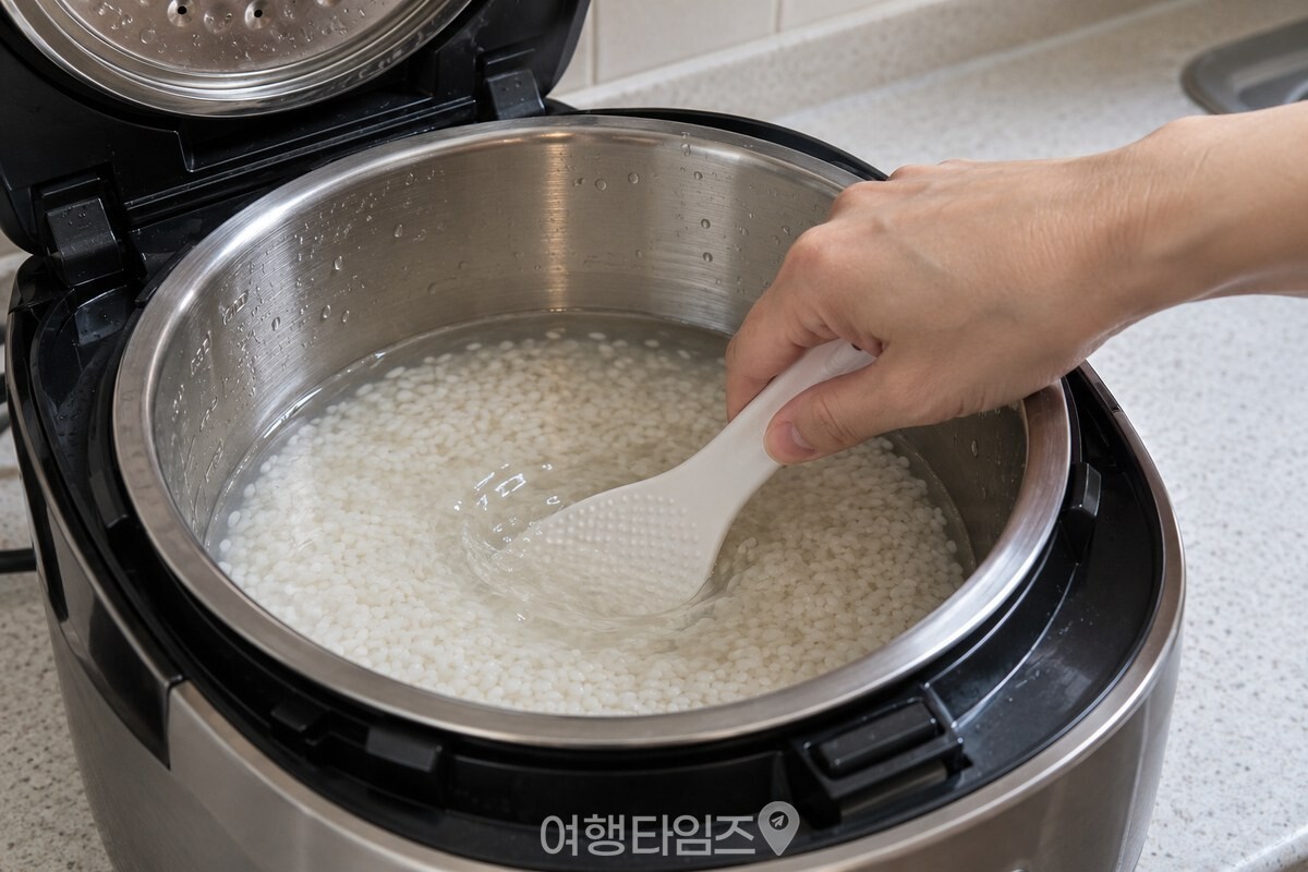 밥솥 안쪽 바닥까지 밥물을 젓는 손 / 기사 이해를 돕기 위한 생성형 이미지