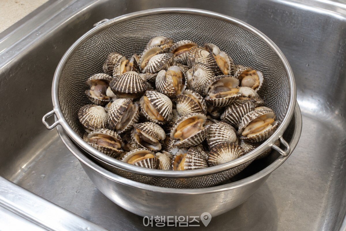 삶은 꼬막을 찬물에 헹구지 않고 체에 건져 둔 모습 / 기사 이해를 돕기 위한 생성형 이미지