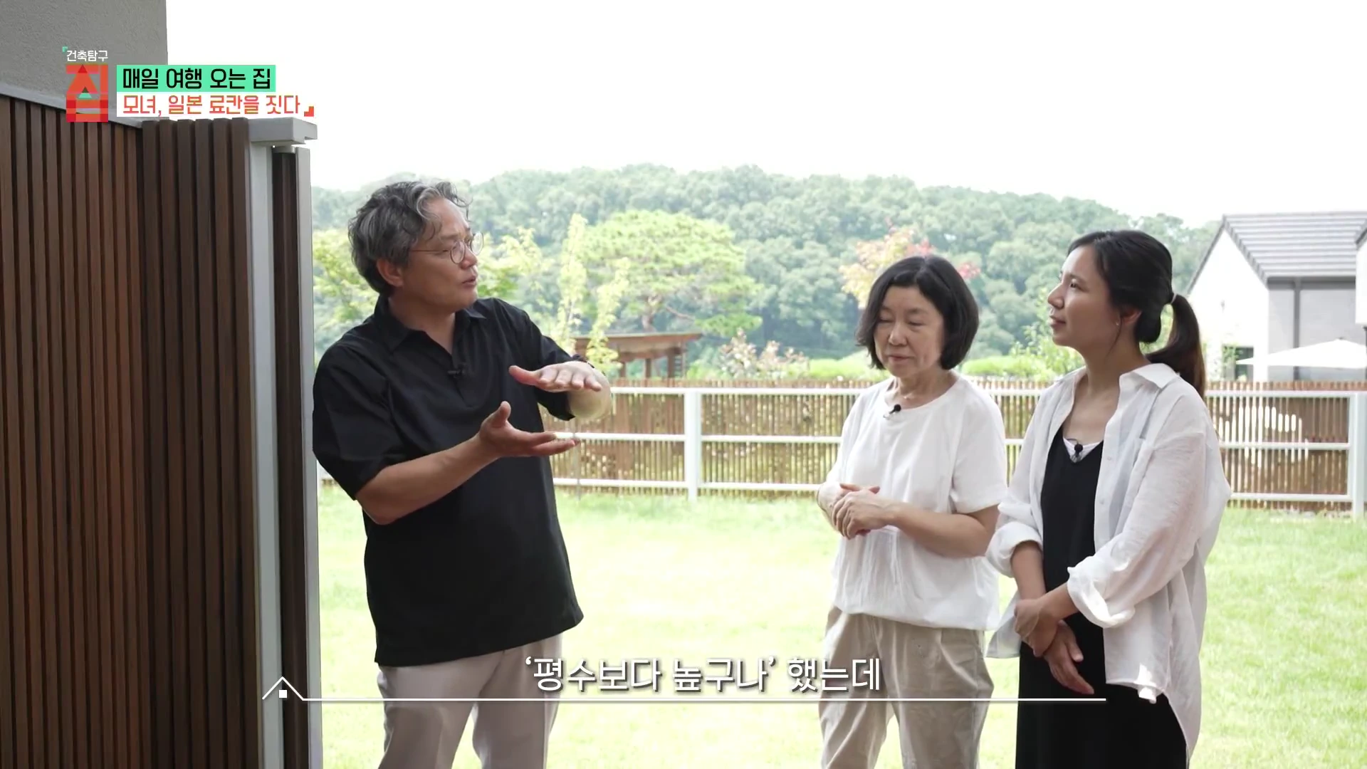 실내에서 야외 정원을 배경으로 서 있는 세 사람의 모습이 담긴 방송 화면으로, 한 남성이 손짓하며 설명하고 두 여성이 이를 듣고 있다.