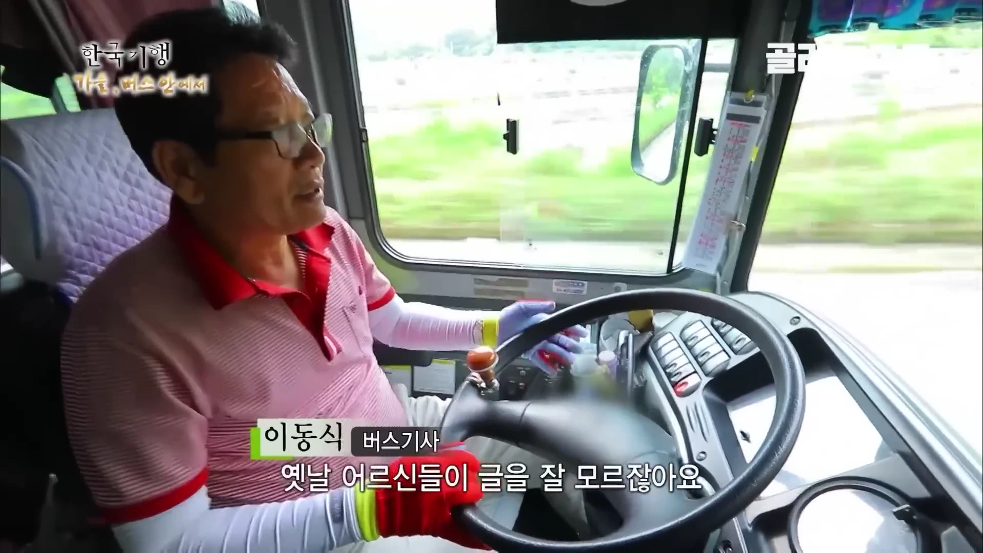 버스 운전석에 앉아 운전대를 잡고 인터뷰에 응하고 있는 중년 남성 버스 기사의 모습입니다.
