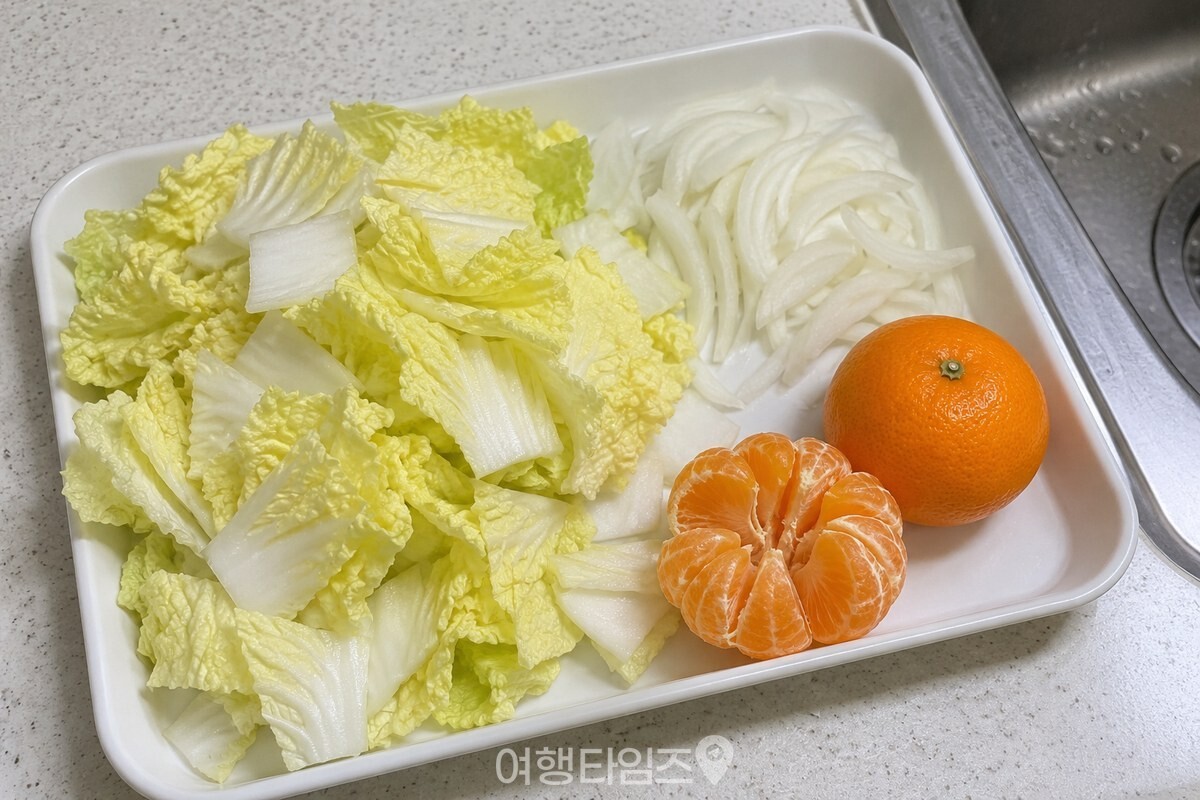 손질한 배추와 귤을 나란히 둔 깨끗한 조리대 / 기사 이해를 돕기 위한 생성형 이미지
