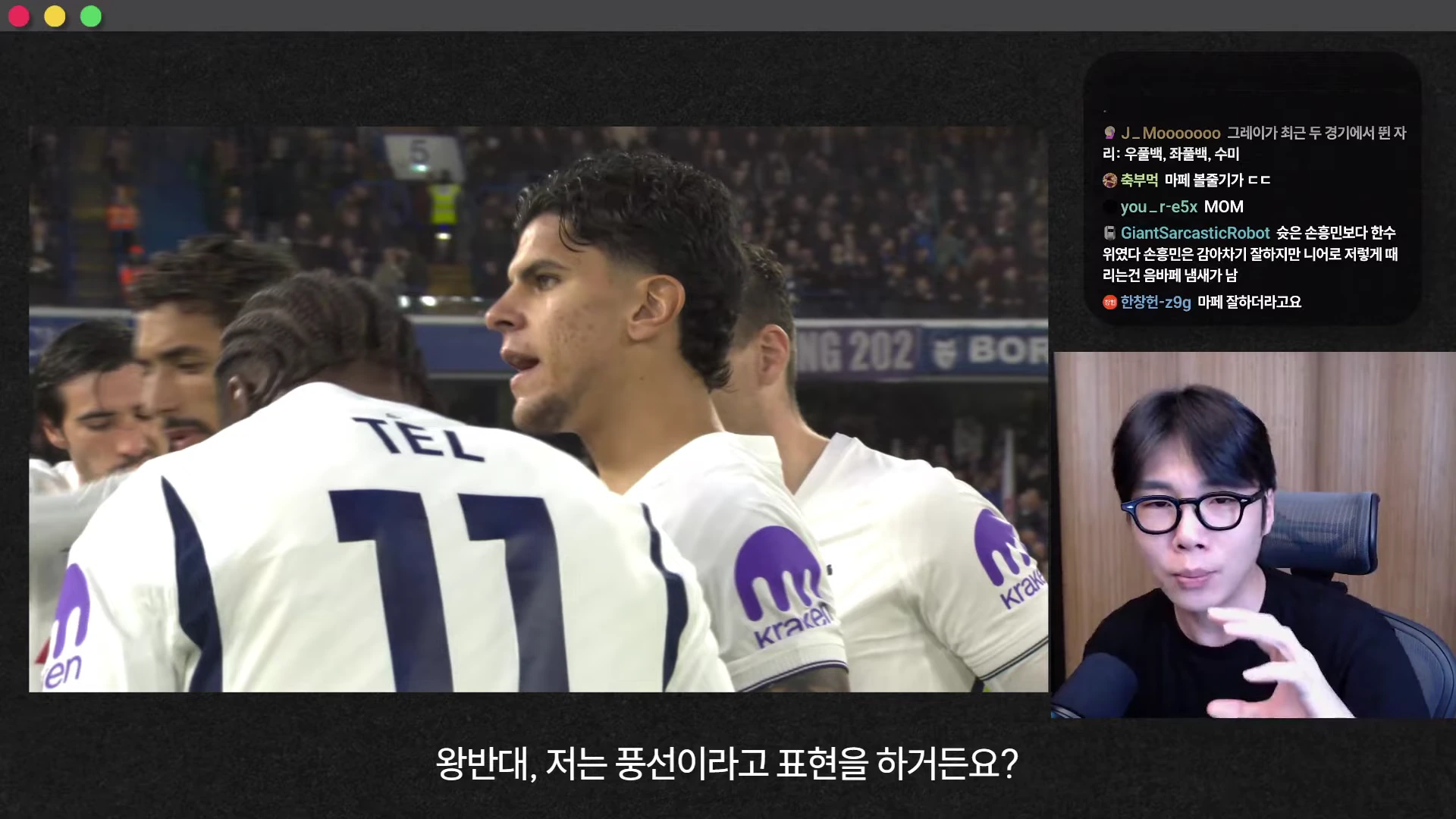흰색 유니폼을 입은 선수들이 경기장에서 모여 있고, 우측 화면에는 안경을 쓴 남성이 마이크를 잡고 설명하는 영상이 송출되고 있습니다.