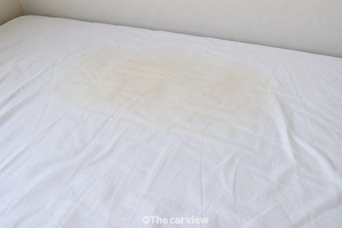 흰 면 시트의 베개 자리에 남은 옅은 누런 기 / 기사 이해를 돕기 위한 생성형 이미지