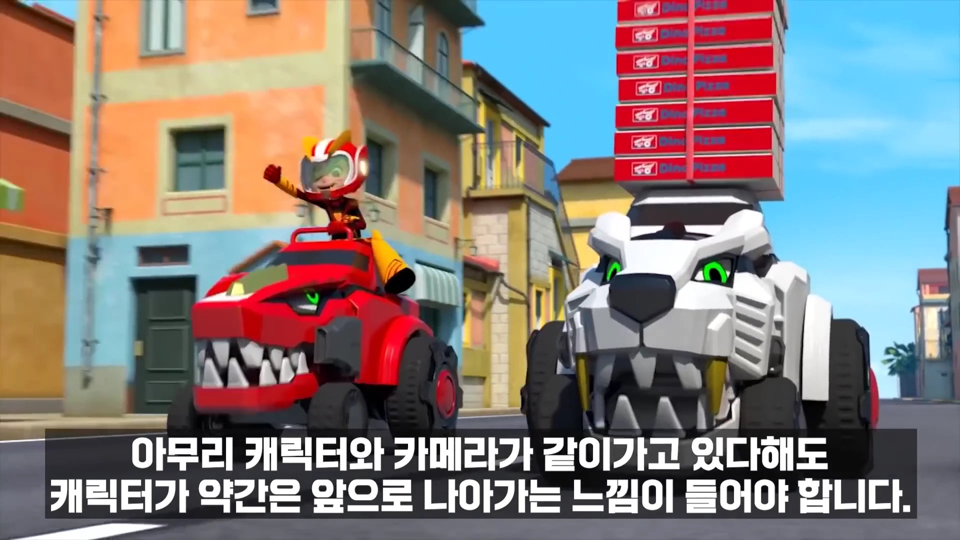 3D 애니메이션 캐릭터가 빨간색 공룡 모양의 차를 타고 옆에 달리는 흰색 사자 모양의 차와 나란히 달리고 있으며 하단에는 자막이 떠 있습니다.