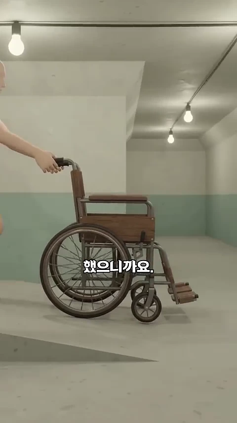 조명이 달린 긴 지하 통로에서 한 사람이 휠체어를 밀고 이동하는 모습이 담긴 3D 그래픽 영상 화면