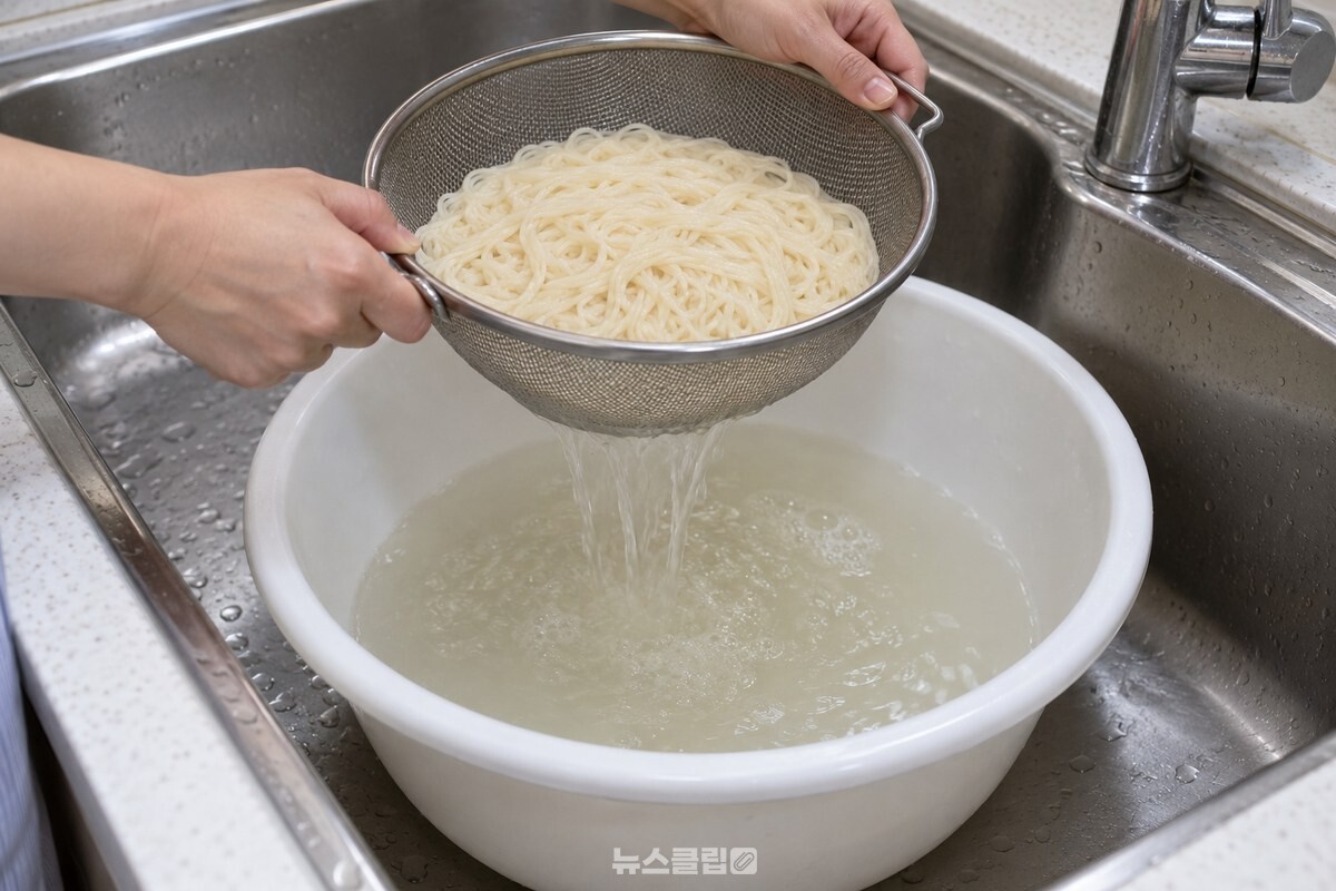 체 아래 설거지통으로 국수 삶은 물을 받는 모습 / 기사 이해를 돕기 위한 생성형 이미지