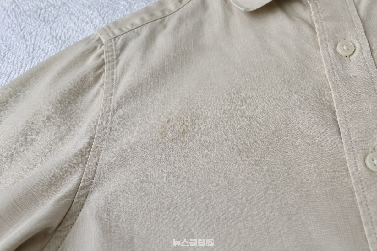 밝은 셔츠 섬유에 남은 옅은 커피 얼룩 부분 / 기사 이해를 돕기 위한 생성형 이미지