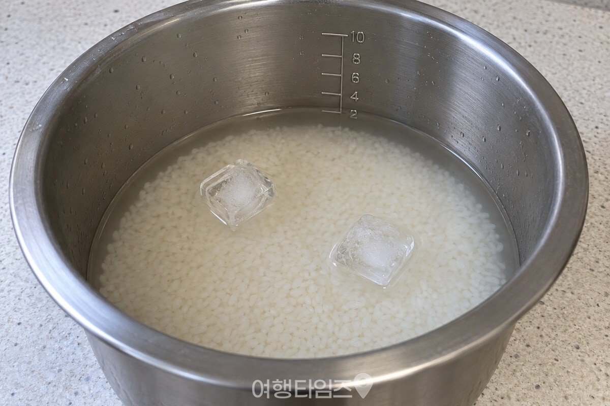 밥물 위에 얼음 두 알을 올린 전기밥솥 내솥 / 기사 이해를 돕기 위한 생성형 이미지