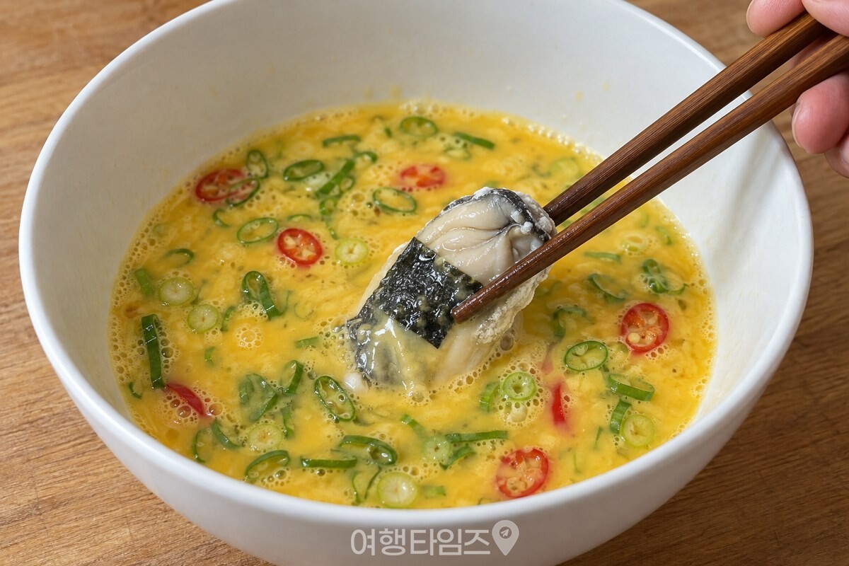 쪽파와 고추를 섞은 달걀물에 김 붙인 굴을 담그는 젓가락 / 기사 이해를 돕기 위한 생성형 이미지