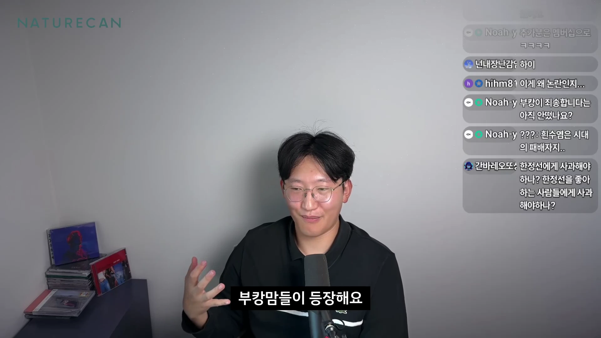 안경을 쓴 남성이 마이크 앞에 앉아 이야기를 나누고 있으며, 화면 오른쪽에는 실시간 댓글 창이 보입니다.